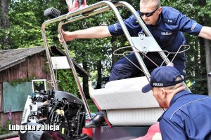 Policjanci przygotowują motorówkę do służby.