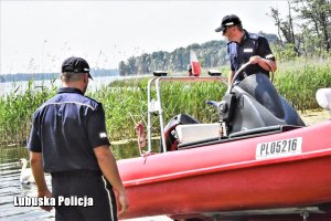 Policjanci przygotowują motorówkę do służby.