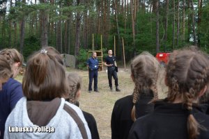 Kontrolujący rozmawiają z wypoczywającą młodzieżą.