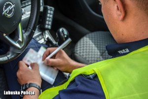 Policjant ruchu drogowego  wypisujący mandat karny
