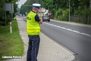 Policjant ruchu drogowego  dokonujący pomiaru prędkości