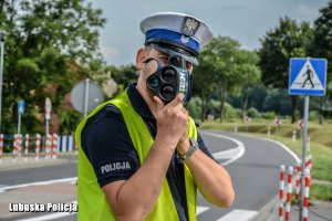 Policjant ruchu drogowego  dokonujący pomiaru prędkości