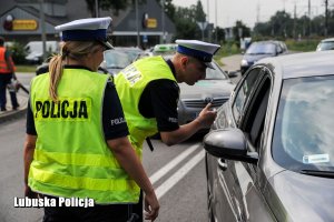 Policjanci ruchu drogowego podczas czynności na drodze.