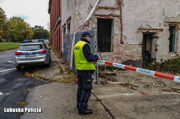 Policjant przy budynku podczas czynności