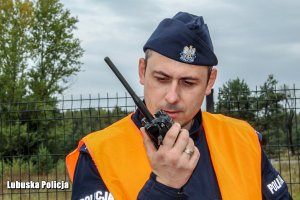 policjant przekazuje informacje przez stację