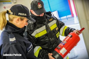 policjantka i strażak sprawdzają gaśnice