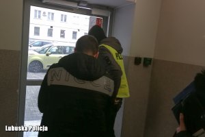 policjanci wyprowadzają zatrzymanego z komendy