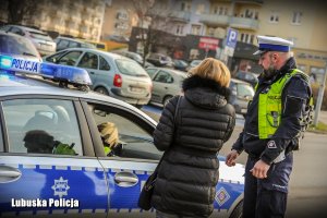 kontrola drogowa - policjant i kobieta przy radiowozie.