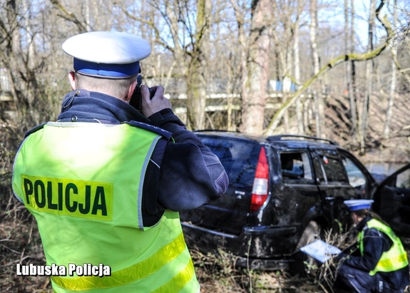 Policjanci ruchu drogowego prowadzący oględziny miejsca zdarzenia i pojazdu