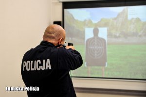 Policjant mierzący z broni w cel