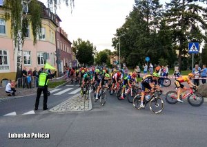 Policjant kieruje ruchem podczas kolarskiego wyścigu.