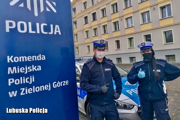 policjant i policjantka stoją przy banerze zielonogórskiej Policji