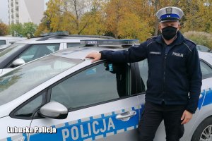 policjant stoi przy radiowozie