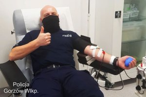 Policjant oddający osocze dla chorych na sars-covid-2 pokazuje kciuka
