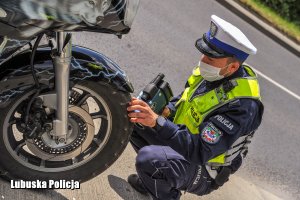 Policjanci ruchu drogowego sprawdzający stan techniczny motocykla
