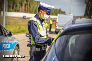 Policjant drogówki podczas kontroli drogowej na drodze.