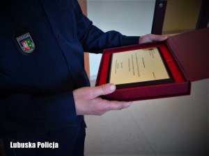 Okolicznościowy grawerton w dłoniach policjanta.