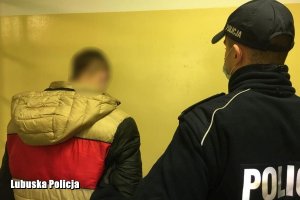 policjant obserwuje zatrzymanego mężczyznę