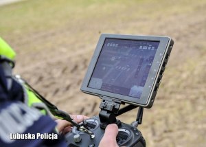 policjant obsługuje kontroler kamery drona