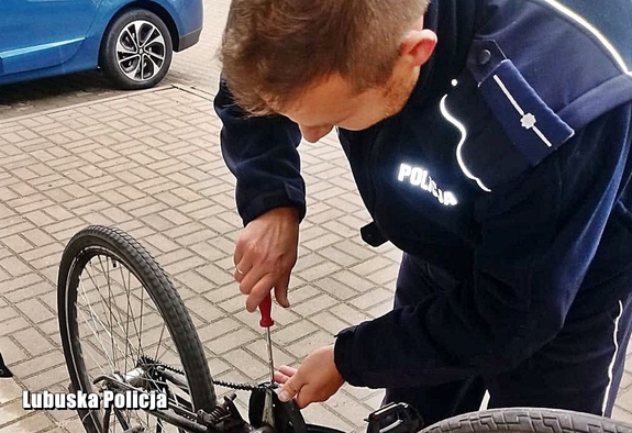 Policjant pomaga zakładać łańcuch