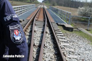 emblemat na mundurze policjanta stojącego na torowisku