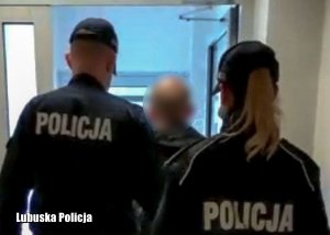 Policjanci prowadzą zatrzymanego