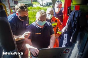 Policjanci i strażacy sprawdzają mapy.