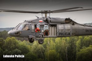 Policjanci w śmigłowcu kontrolujący liny, na których opuszczają się kontrterroryści