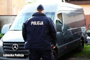 Policjant przed odzyskanym mercedesem