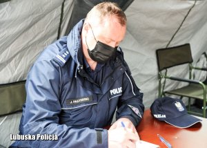 Policjant wypełnia formularz.