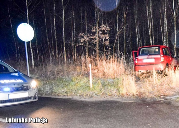 policyjny radiowóz, a obok samochód osobowy.