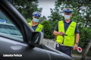 policjant i policjantka obserwują kontrolowany pojazd