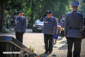 policjanci oddają honor do Krzyża Katyńskiego