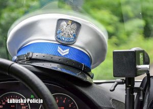 Czapka policjanta ruchu drogowego na desce rozdzielczej pojazdu.