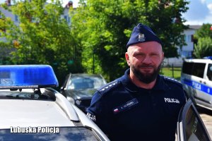Policjant w mundurze przy radiowozie