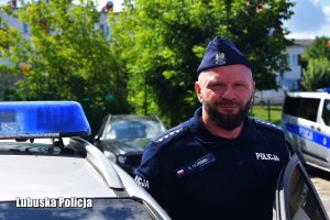 Policjant w mundurze przy radiowozie