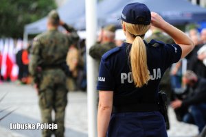 Policjantka i żołnierze salutują