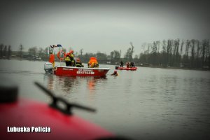 strażacy na łodzi ratują tonącego mężczyznę