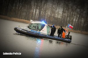 policjanci płyną na łodzi