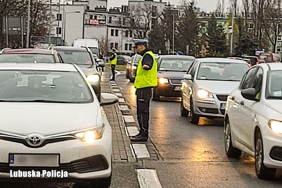 policjant kieruje ruchem ulicznym pokazując jazdę na suwak