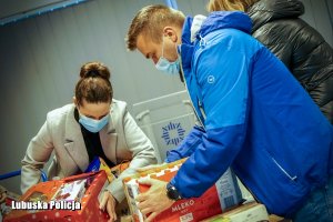 Mężczyzna i kobieta przenoszą paczki świąteczne.