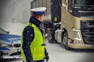 Policjant ruchu drogowego patrzący na przejeżdżająca ciężarówkę