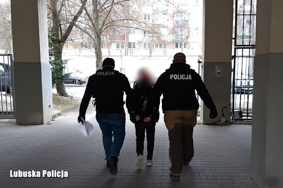 Dwóch policjantów prowadzi zatrzymaną