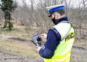 Policjant drogówki podczas obsługi pulpitu sterowniczego drona.