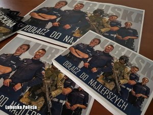 Plakaty zachęcające do wstąpienia w szeregi lubuskiej policji rozłożone na biurku