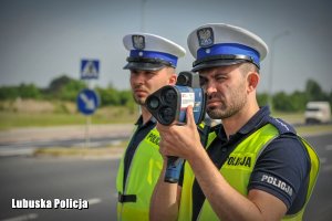 Dwóch policjantów ruchu drogowego podczas kontrolowania prędkości na drodze