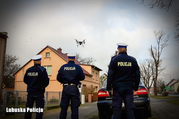 trzech umundurowanych policjantów i dron w powietrzu