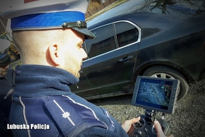 policjant obsługujący urządzenie do sterowania dronem