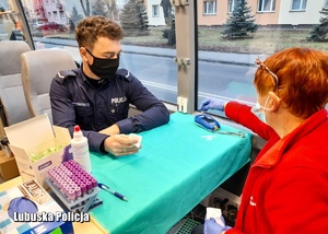 Policjant i pracownik medyczny podczas sprawdzania zawartości cukru we krwi
