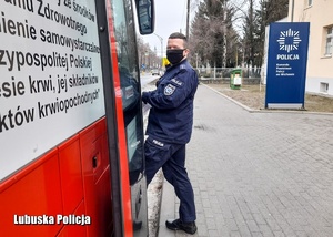 Policjant wsiadający do mobilnego centrum krwiodawstwa